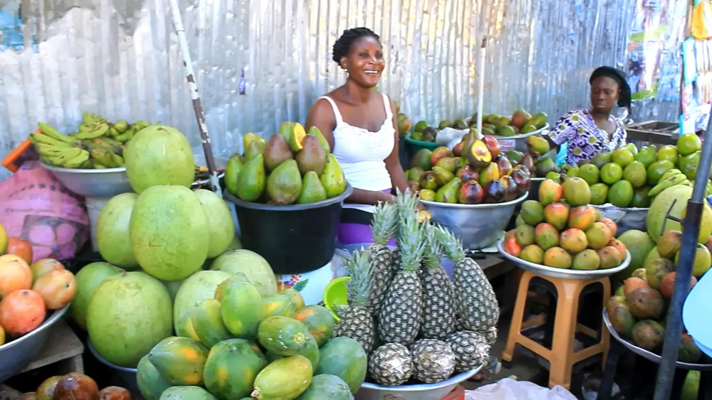 A trader selling fresh fruit at a Ghanaian market